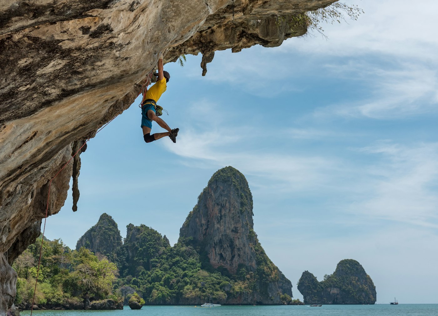 A climber on an overhang above the sea
